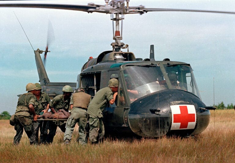 A wounded member of the 1st Plt. Company "C," 25th Infantry Division, is helped to a waiting UH-1D "Iroquois" helicopter in Vietnam, May 10, 1967, during the Vietnam War.  (AP Photo)